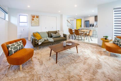 a living room with a couch and chairs and a table at Modern 6BD Homes Carpark Avebury Park Avon River in Christchurch