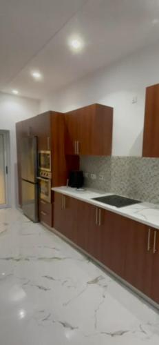 a kitchen with marble counter tops and wooden cabinets at Gated Community in Kwedonu