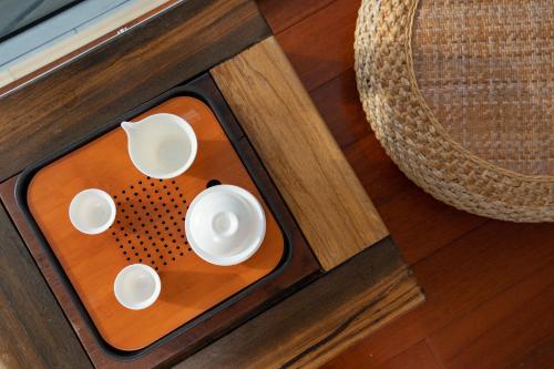 a cup and saucer on top of a wooden table at 东山一个庐野奢帐篷营地 in Yanya