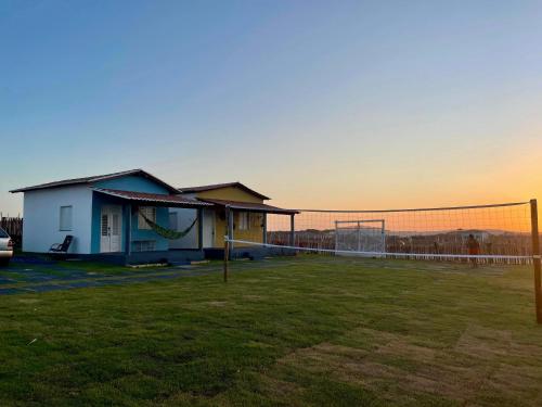 a house with a volleyball net in a field at Villa Careca in Luis Correia