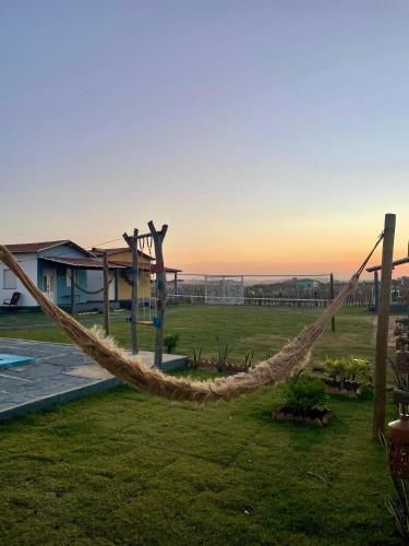 a hammock in a yard with the sunset in the background at Villa Careca in Luis Correia