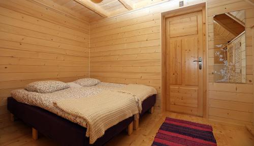 - une chambre avec un lit dans une pièce en bois dans l'établissement Dom Numer 3, à Zakopane