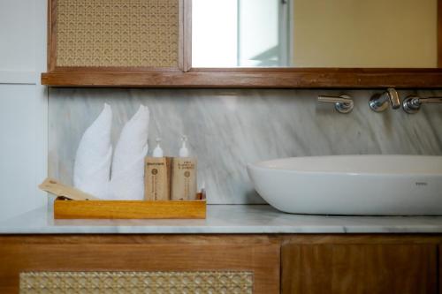 a bathroom counter with a sink and a mirror at Fourteen Roses Boutique Hotel, Kuta in Legian