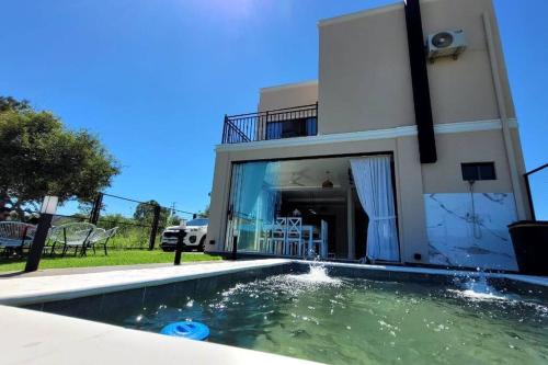 a house with a swimming pool in front of a house at La Soñada casa quinta Premium in Piribebuy