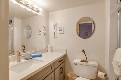 a bathroom with a sink and a toilet and a mirror at Kahana Reef in Kahana
