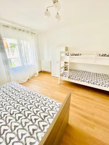 Cette chambre blanche dispose de deux lits et d'une fenêtre. dans l'établissement Maison proche Paris, Aéroport CDG, Stade de France, à Drancy