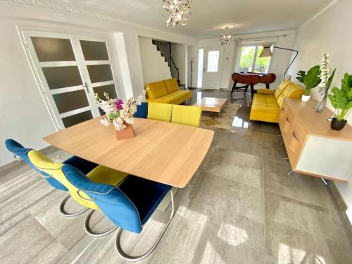 un salon avec une table et des chaises en bois dans l'établissement Maison proche Paris, Aéroport CDG, Stade de France, à Drancy