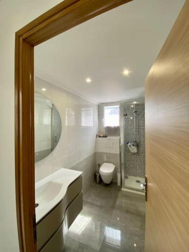 une salle de bain avec un lavabo, des toilettes et un miroir dans l'établissement Maison proche Paris, Aéroport CDG, Stade de France, à Drancy