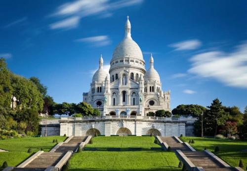ein großes weißes Gebäude mit einem üppigen grünen Rasen in der Unterkunft Maison proche Paris, Aéroport CDG, Stade de France in Drancy