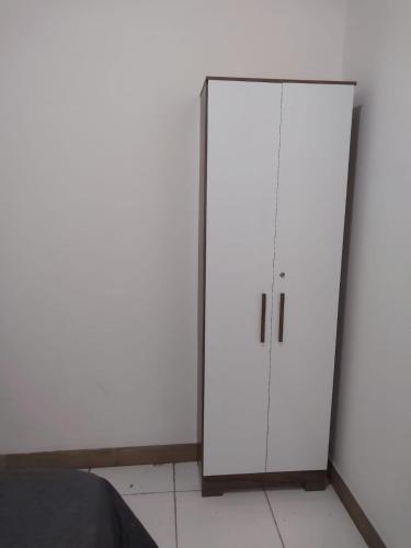 a white cabinet in a room with a bed at Fênix hospedaria in Natal