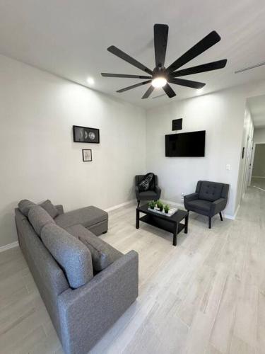 a living room with a couch and a ceiling fan at Welcome to Launchpad Living! in Brownsville