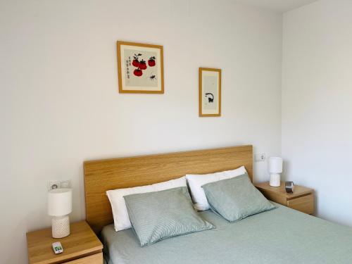 a bedroom with a bed with two lamps and two pictures on the wall at Pool, Beach and Sun in Mar Menor Golf Resort in Torre-Pacheco