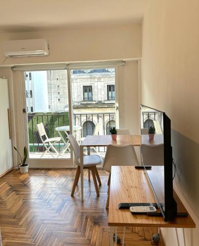 a living room with a table and a large window at Apartamento BA Obelisco in Buenos Aires