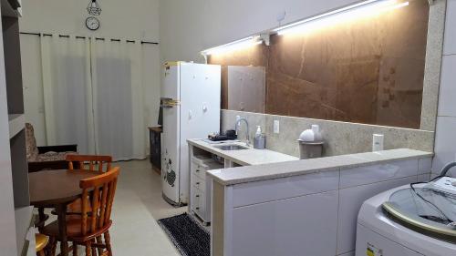 a kitchen with a sink and a refrigerator at Recanto do surf in Imbituba