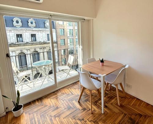 a dining room with a table and a large window at Apartamento BA Obelisco in Buenos Aires