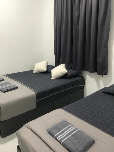 two beds sitting next to each other in a room at DyMaz Salam Homestay in Seri Iskandar