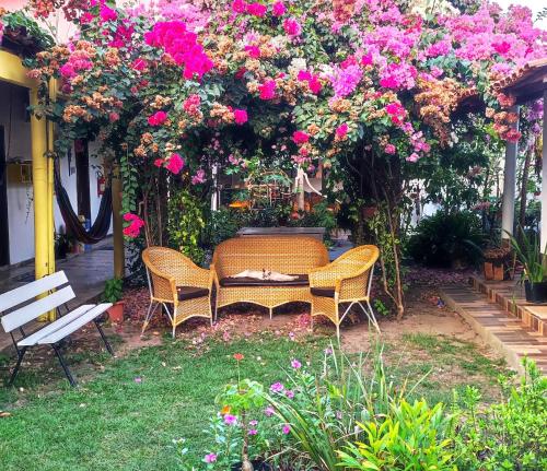 a garden with a table and chairs and flowers at Pousada Solar Encanto do Marajó in Soure