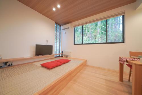 a living room with a red couch and a tv at Queens Park CK Village Niseko Hirafu in Kutchan