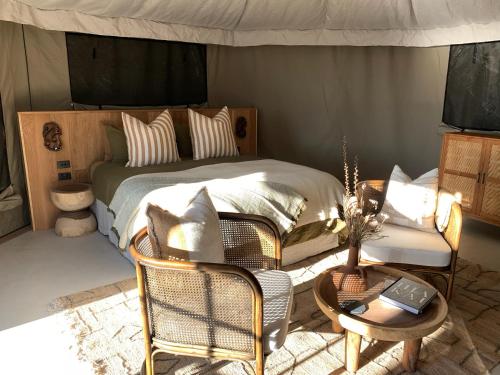 a bedroom with a bed and a table and chairs at Te Whaanga Retreat & Spa in Raglan