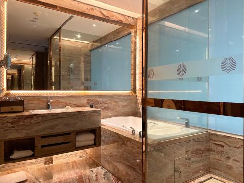 a bathroom with a tub and a large mirror at Vaperse Hotel Guangzhou Zhujiang New Town - Free Shuttle Bus & Registration Counter During Canton Fair in Guangzhou