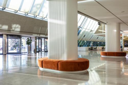 a lobby with white columns and a large building at Crowne Plaza Belgrade by IHG in Belgrade
