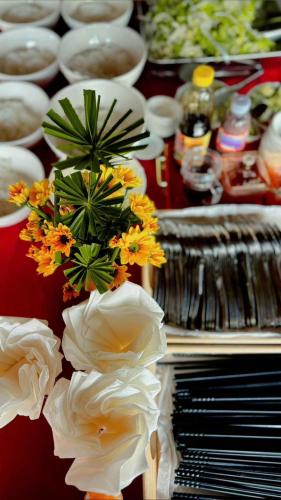 a vase of flowers on a table next to a piano at Mộc Villas in Phuoc Buu