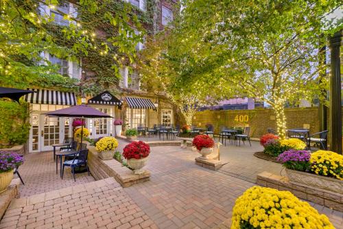 a patio with tables and chairs and flowers and trees at Best Western Plus Hawthorne Terrace Hotel in Chicago