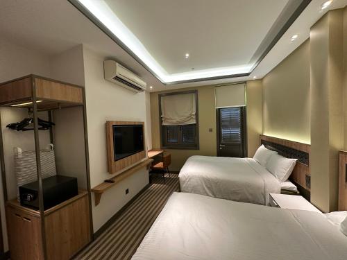 Una habitación de hotel con dos camas y un televisor. en Dash Living Rochor, en Singapur