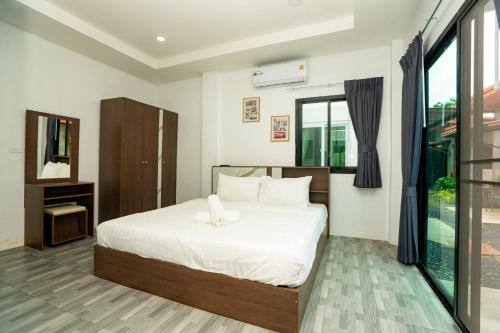 a bedroom with a bed and a large window at Lovely 2 Bed share Pool Apt near Beach in Ban Lum Fuang