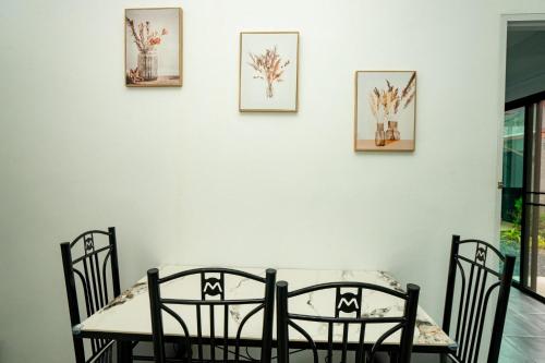 a dining room with a table and chairs against a wall at Lovely 2 Bed share Pool Apt near Beach in Ban Lum Fuang