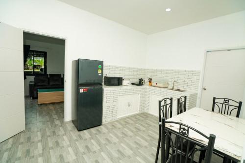 a kitchen with a refrigerator and a table and chairs at Lovely 2 Bed share Pool Apt near Beach in Ban Lum Fuang