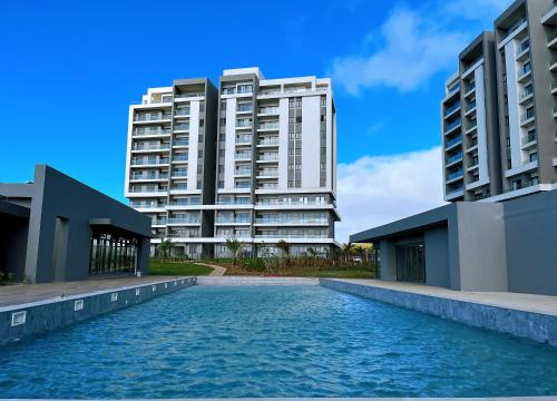 2 grands bâtiments et une piscine en face d'un bâtiment dans l'établissement Pool & Mountain View Luxury Serviced Apartments at Minissy, à Moka