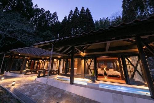 a house in the woods with a view of a bedroom at Yufuin Hotel Mori-no-Terrace in Yufuin