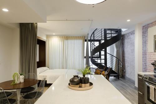 a bedroom with a bed and a staircase in a room at Abode Los Angeles - Downtown South Park in Los Angeles