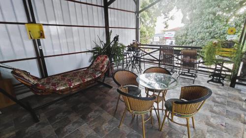 a patio with chairs and a glass table and chairs at Pousada Solar Encanto do Marajó in Soure