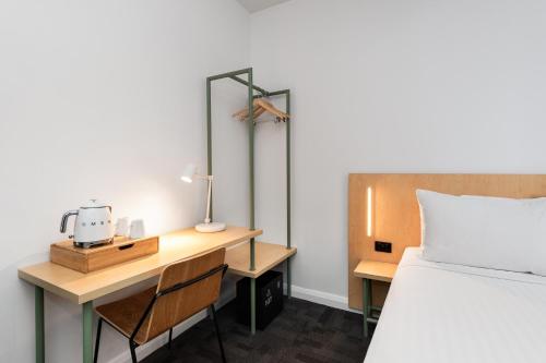 a bedroom with a bed and a desk and a bed sidx sidx sidx at YHA Sydney Central in Sydney