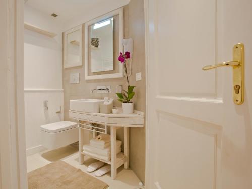 a white bathroom with a sink and a toilet at Primo Piano Suites in Rome