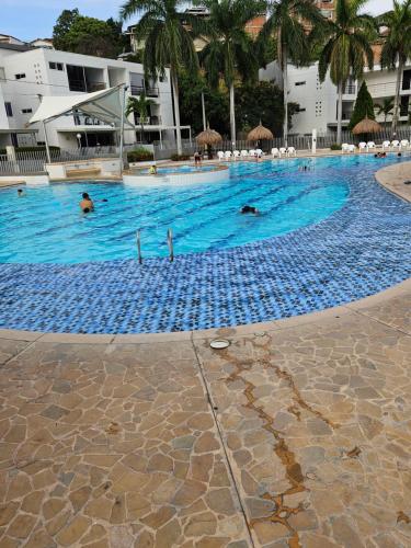 a large swimming pool with people in the water at Apartasol Ciudadela Santa Fé "El Refugio" in Santa Fe de Antioquia