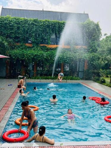 a group of people in a swimming pool with a fountain at ST Homestay Tản Lĩnh - Venuestay in Mỹ Khê