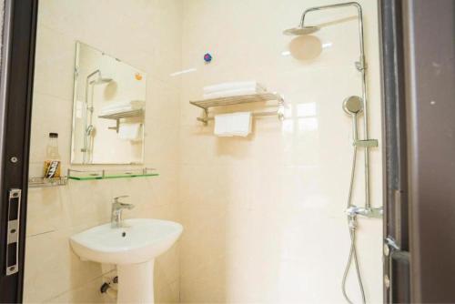 a white bathroom with a sink and a shower at ST Homestay Tản Lĩnh - Venuestay in Mỹ Khê