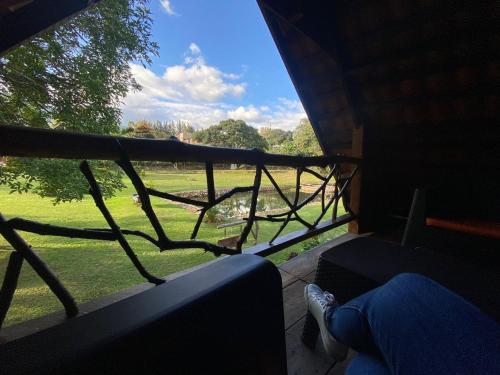 a view of a field from a window of a house at Laguna Lodge El Zarzal in Valle de Ángeles