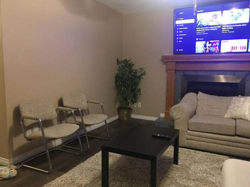 a living room with a couch and chairs and a tv at Renovated 4 bedrooms 20 sleeps Shopping Center in Edmonton
