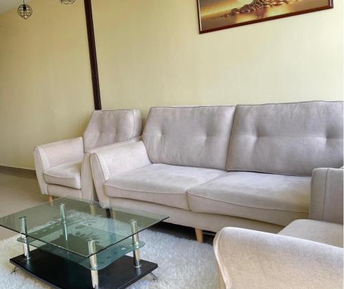 a living room with a couch and a glass table at Monkey Mansion in Kuala Lumpur