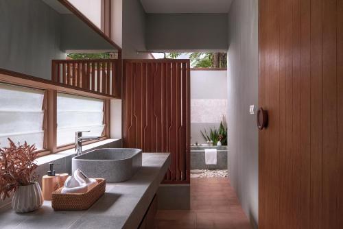 a bathroom with a sink and a large window at Amaya Kampot Homestays in Kampot