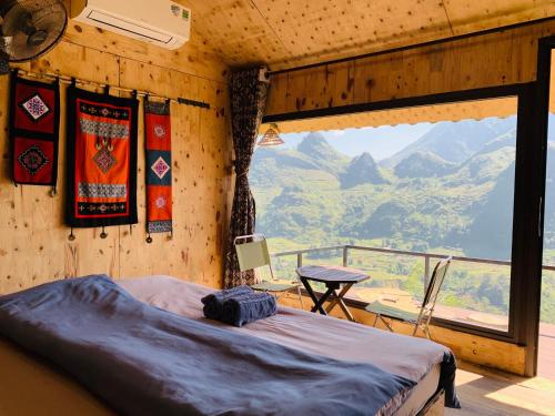 a bedroom with a bed and a view of a mountain at Du peak home in Làng Cac