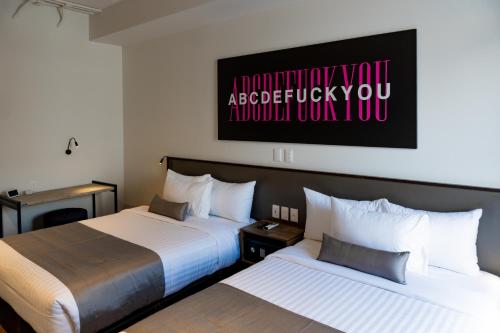 two beds in a hotel room with a picture on the wall at ALT URBANA in León
