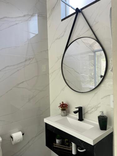a bathroom with a sink and a mirror on the wall at Casa com banheira in Governador Celso Ramos