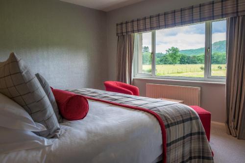 a bedroom with a bed and a large window at The Grand at Grasmere in Grasmere