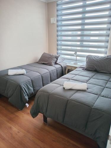 two twin beds in a room with a window at Dpto Nuevo, Full Equipado, 2D, 2B, Céntrico, Mirador del Bio Bio, a minutos del aeropuerto, mall, Excelente conectividad in Concepción