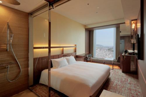 a hotel room with a bed and a shower at Candeo Hotels Osaka Hirakata in Hirakata